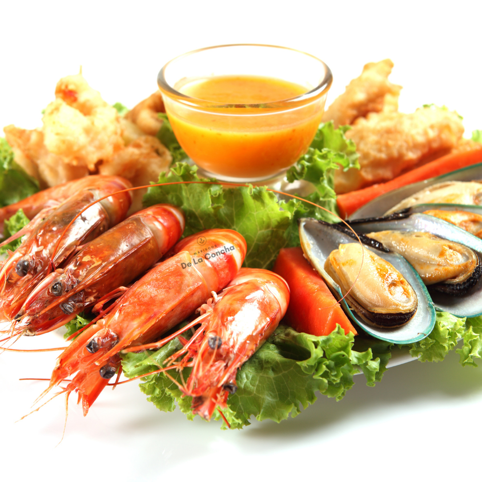 Mariscos y pescados en un plato con ensalada y aderezo