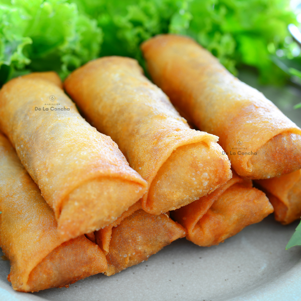 Arrollados Primavera fritos sobre un plato y con lechuga de fondo