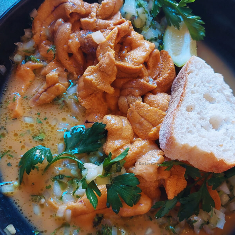 Erizos con salsa verde al matico en fuente de greda con pan