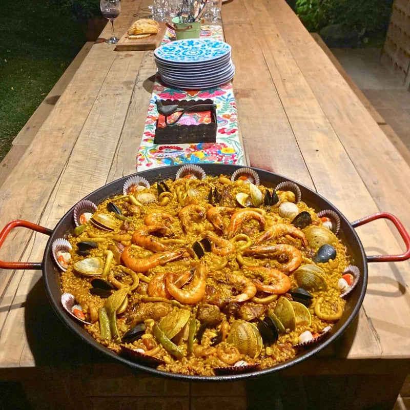 Paella mar y tierra sobre una mesa campestre