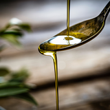 Aceite de oliva extra virgen fluyendo por una cuchara