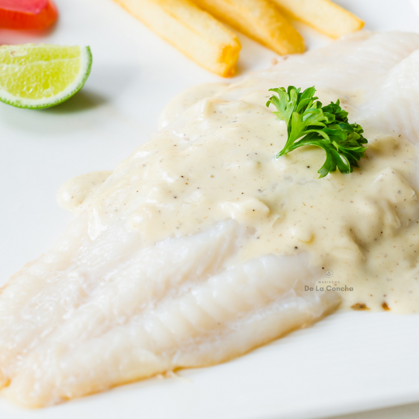 Plato de filete de blanquillo con salsa blanca y acompañado de papas fritas y limón