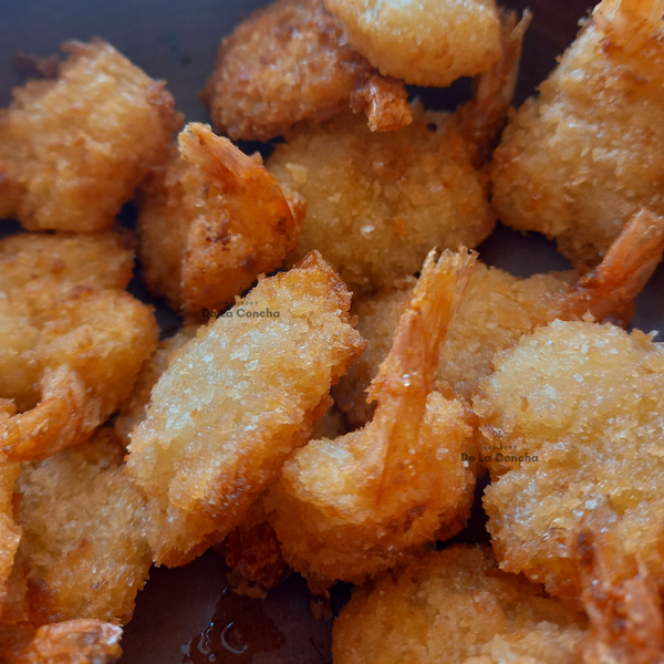 Colitas de camarones empanizadas y fritas sobre un plato