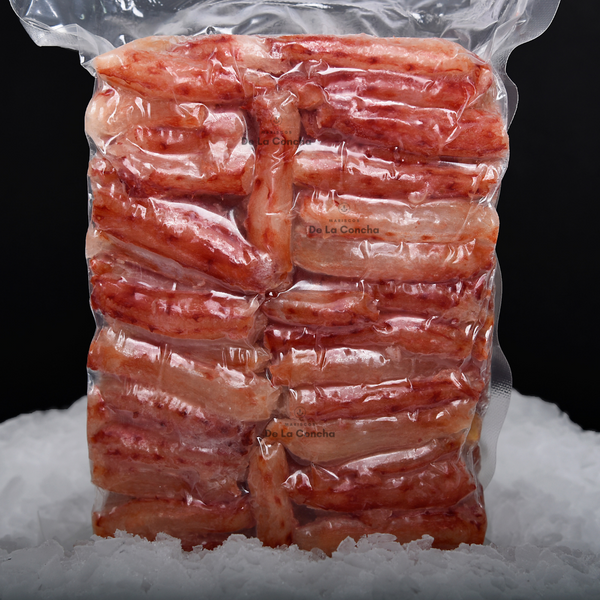 Bolsa de carne de centolla premium (Chilean King Crab) al vacío sobre una cama de hielo y fondo negro.
