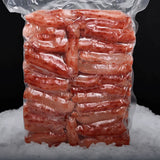 Carne de centolla congelada premium (Chilean King Crab) al vacío sobre una cama de hielo y fondo negro.