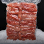 Carne de centolla congelada premium (Chilean King Crab) al vacío sobre una cama de hielo y fondo negro.