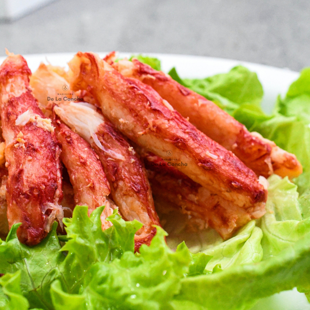 Plato de carne de patitas de centolla (Chilean King Crab) cocida sobre una cama de lechuga.