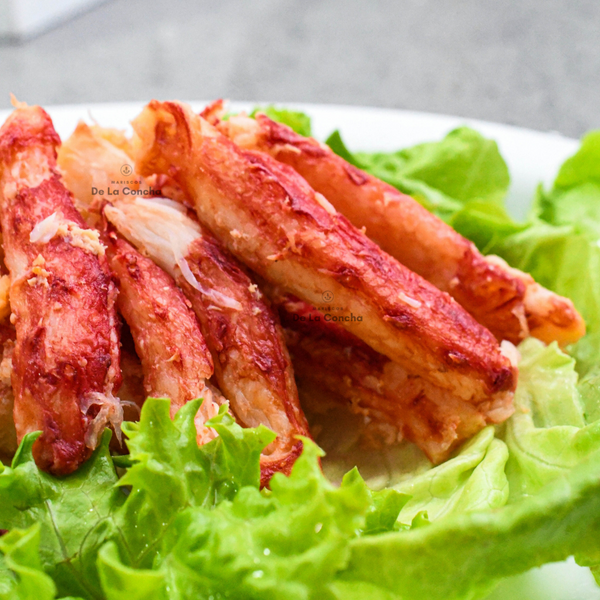 Plato de carne de patitas de centolla (Chilean King Crab) cocida sobre una cama de lechuga.