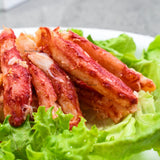 Plato de carne de patitas de centolla (Chilean King Crab) cocida sobre una cama de lechuga.