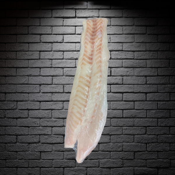 Filete de congrio dorado grande sobre un fondo negro de ladrillo