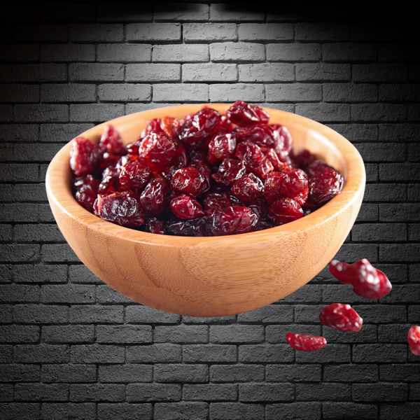 Bol de madera con cranberries deshidratados en su interior sobre un fondo negro de ladrillos