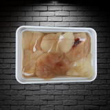 Mejillas de congrio dorado en bandeja de 200g sobre fondo de ladrillos