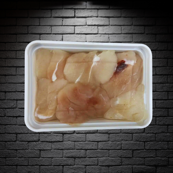 Mejillas de congrio dorado en bandeja de 200g sobre fondo de ladrillos