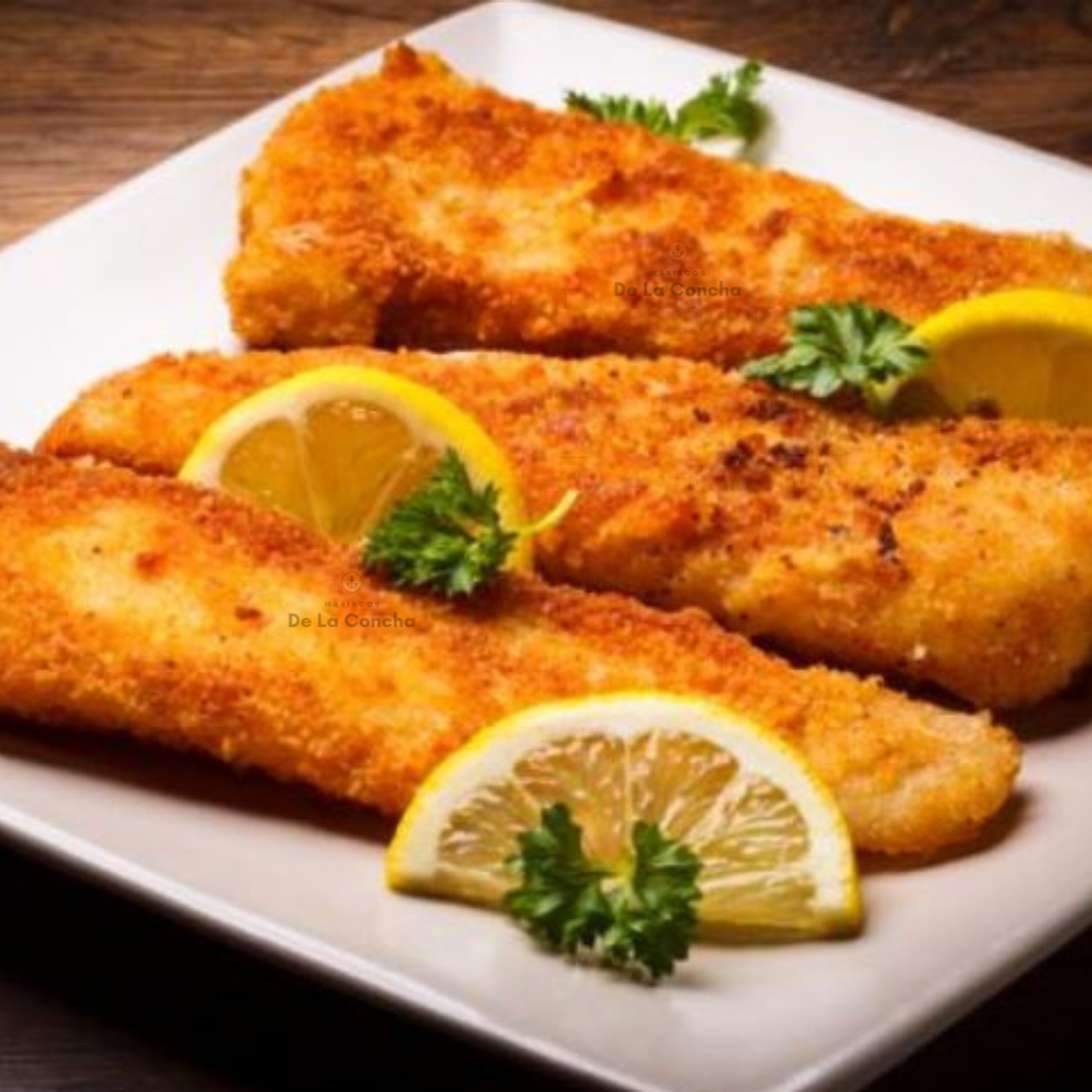 Filetes de merluza gayi apanados en un plato blanco con limon