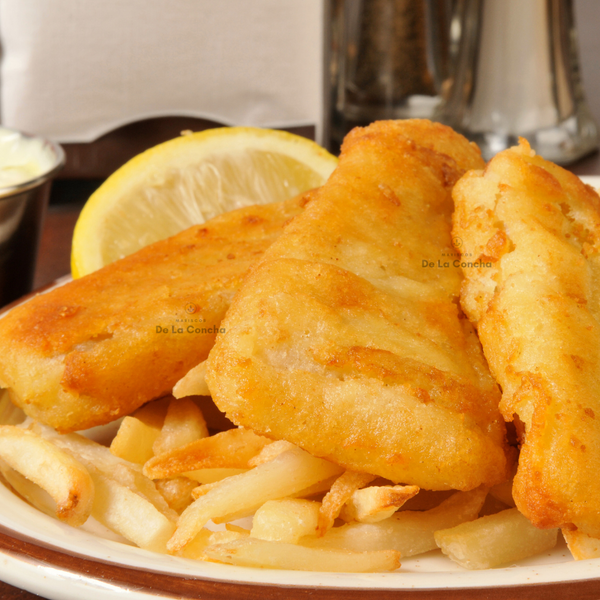 Barra de merluza austral frita rebosada sobre cama de papas fritas sobre un plato