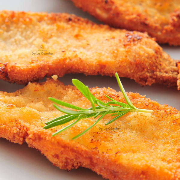 Milanesa frita de pollo (escalopa de pollo) coronada por una hoja de romero 