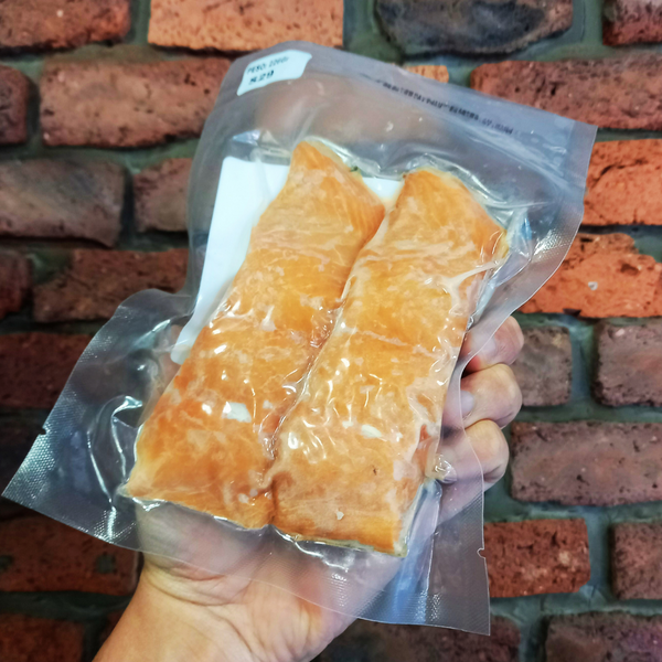Dos trozos de salmón ahumado en caliente sobre fondo de ladrillo