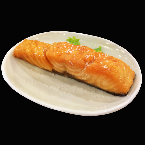 Trozo de salmón ahumado en caliente sobre un plato blanco