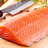 Filete de salmon fresco con piel sobre una tabla de madera