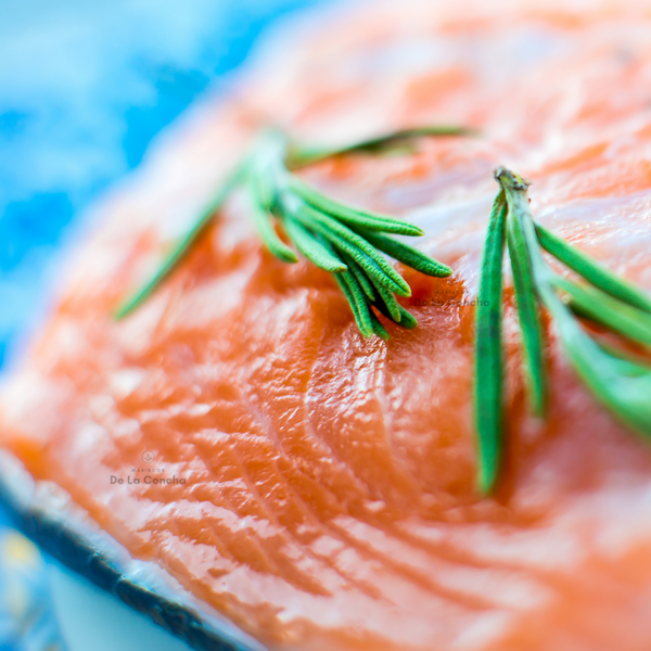 Pieza de salmón fileteado sin piel adornado con romero