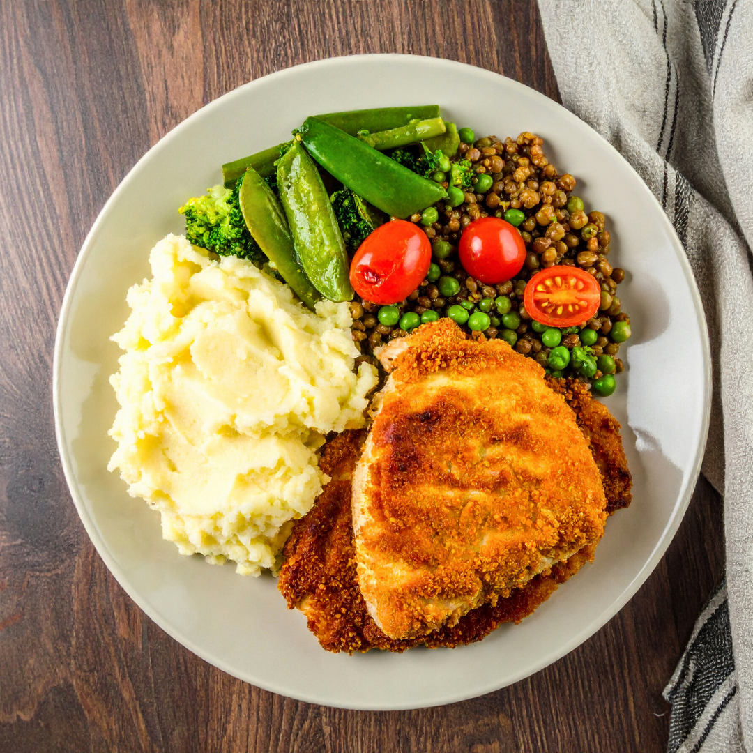 Suprema de pollo con pure de papas y arvejas en un plato