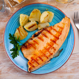 Trucha con piel fileteada asada con papas al horno en plato azul