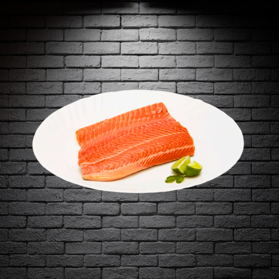 Trozo de trucha fileteada sin piel en un plato blanco sobre fondo de ladrillo negro 