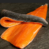Filete de salmón coho con piel sobre una superficie oscura